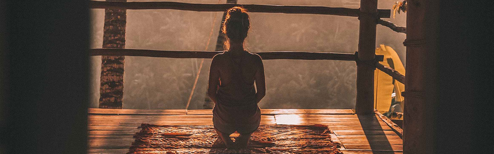 Woman sitting on knees on deck in the sunlight