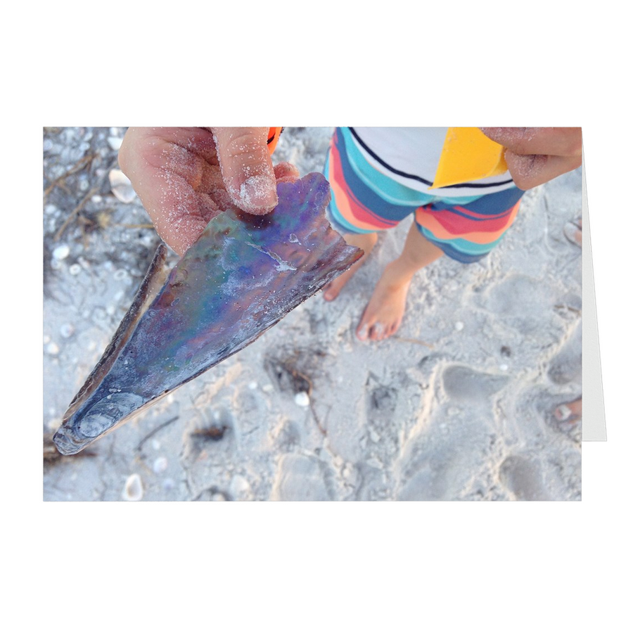 Meghan Nathanson Artistry color photo of child's hands holding a shell on the beach on folded greeting card
