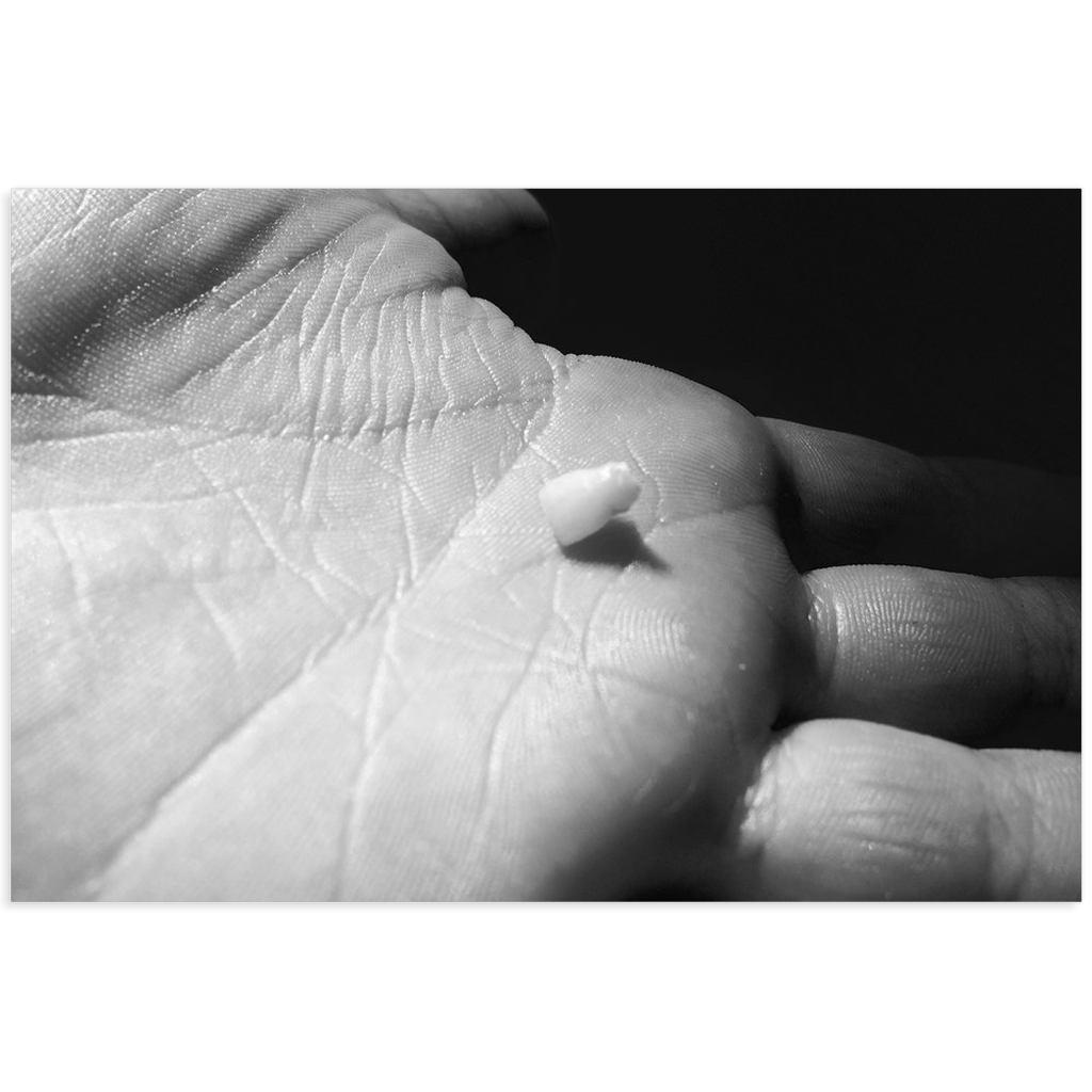 Meghan Nathanson Artistry black and white photo of a child's hand holding their first tooth on mini canvas print